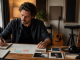 Independent musician planning a music marketing campaign at a studio desk