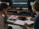 Musician and producer reviewing release materials and audio in a studio