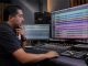 Producer reviewing aligned multitrack stems in a recording studio