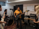 Four-piece independent band rehearsing together in a practice room