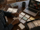 Musician organizing song records, credits, artwork, and files at a table