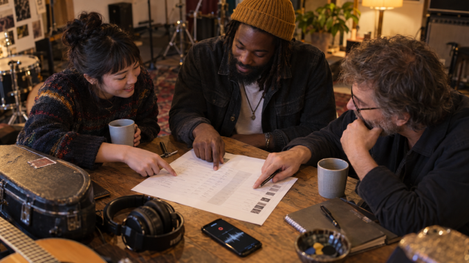 Three independent musicians confirm contributor roles together on a release-credit worksheet after a recording session.