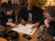 Three independent musicians confirm contributor roles together on a release-credit worksheet after a recording session.
